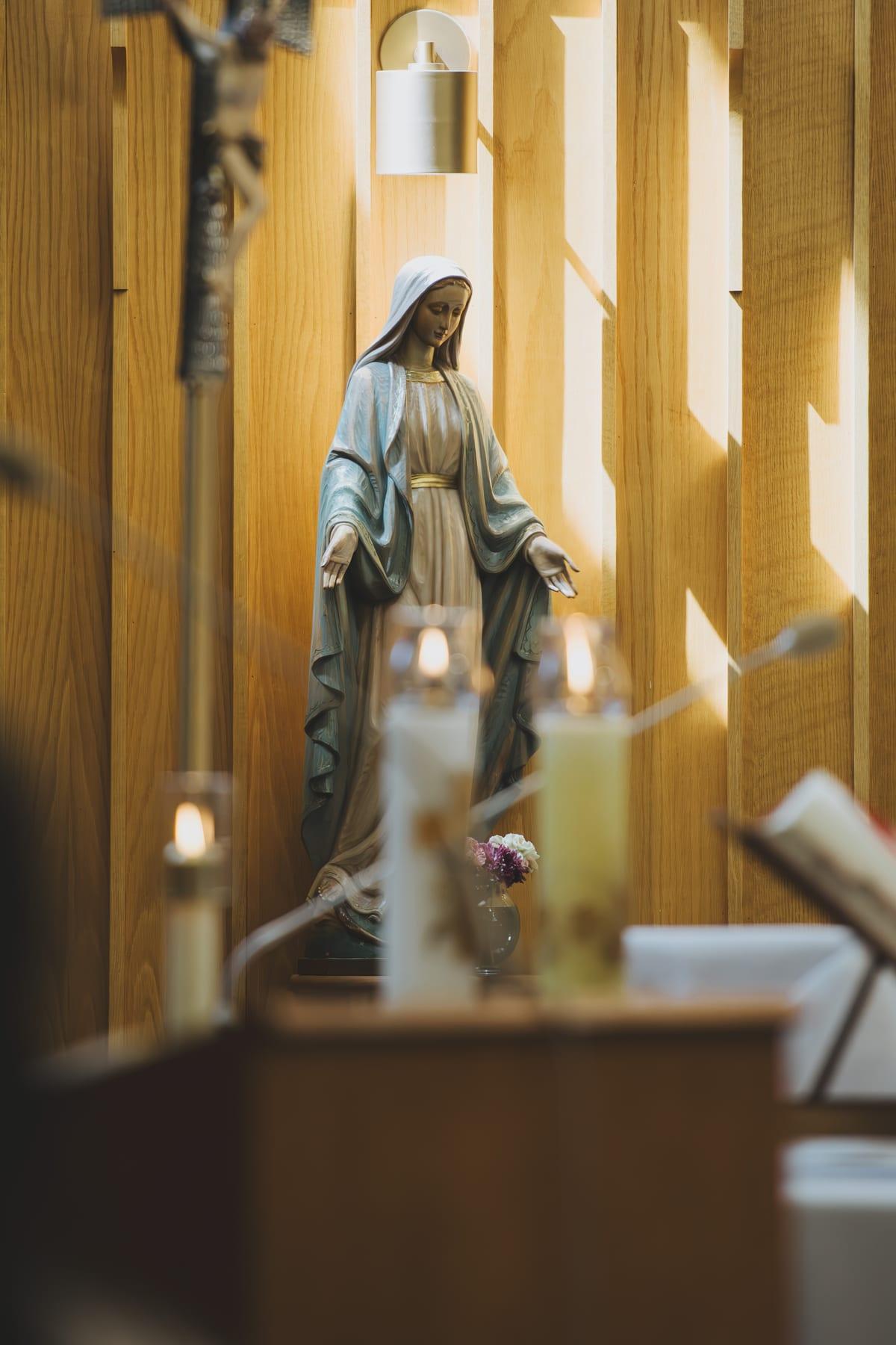 The Marian shrine with votive candles burning and fresh flowers at Our Lady’s feet