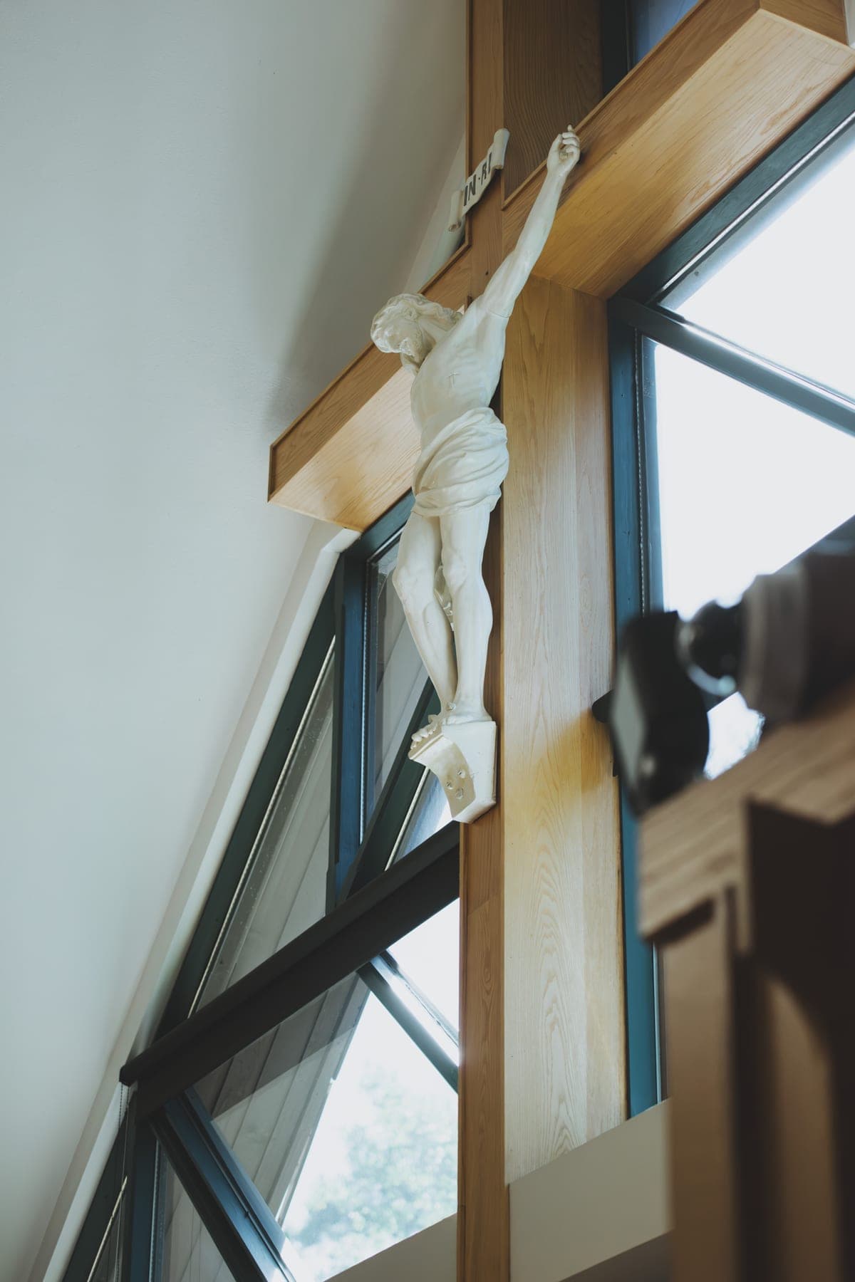 The sanctuary crucifix seen from below against the angled windows of the church