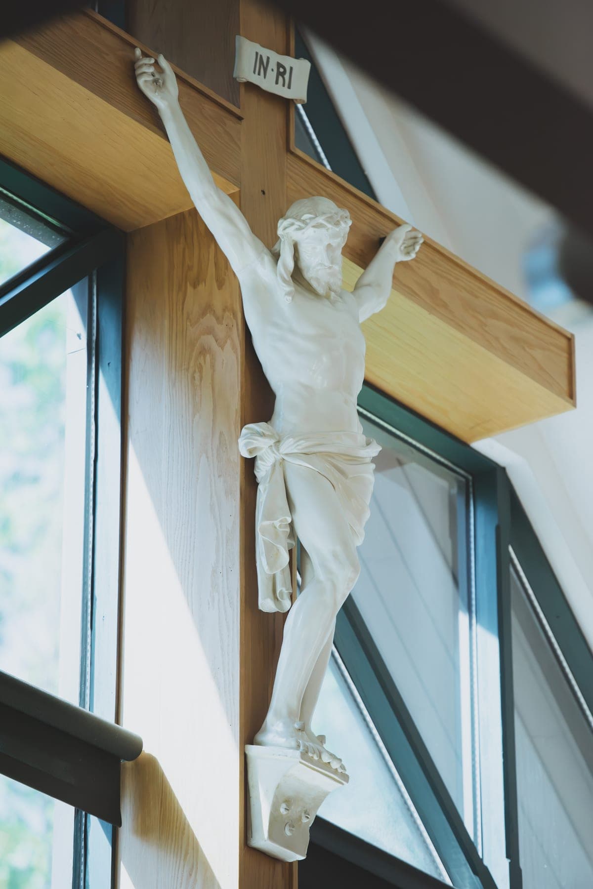 The carved crucifix above the sanctuary at St. Patrick’s, lit by daylight from the clerestory windows
