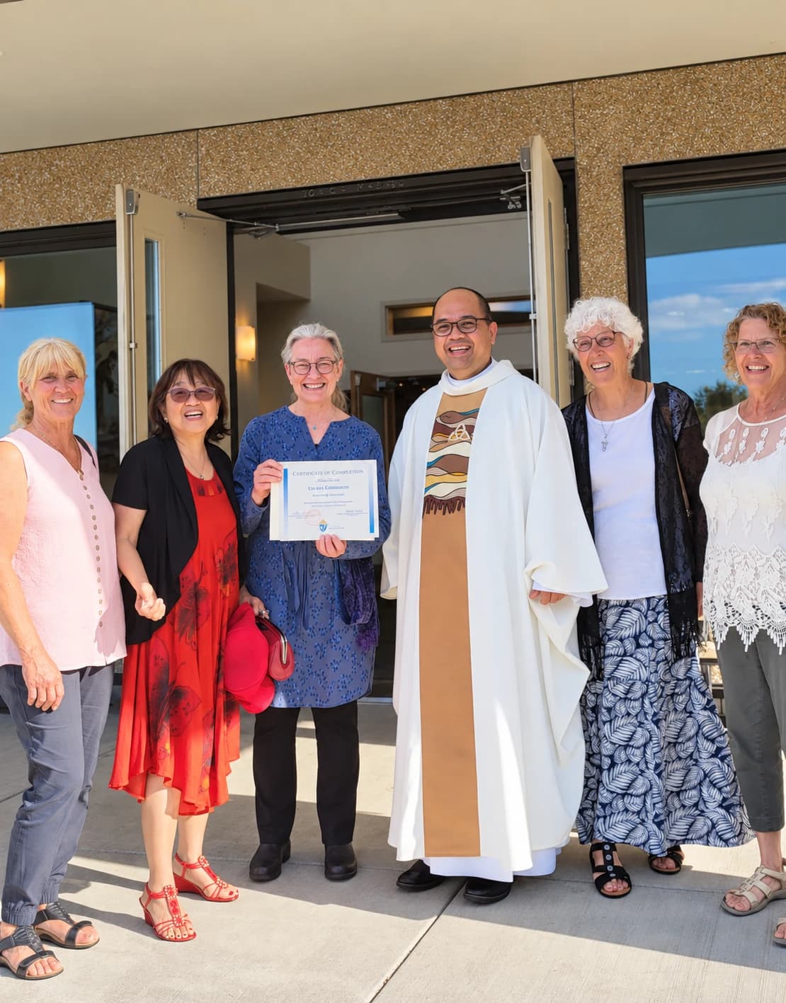 Father Mel and parishioners smiling together outside the church after Mass