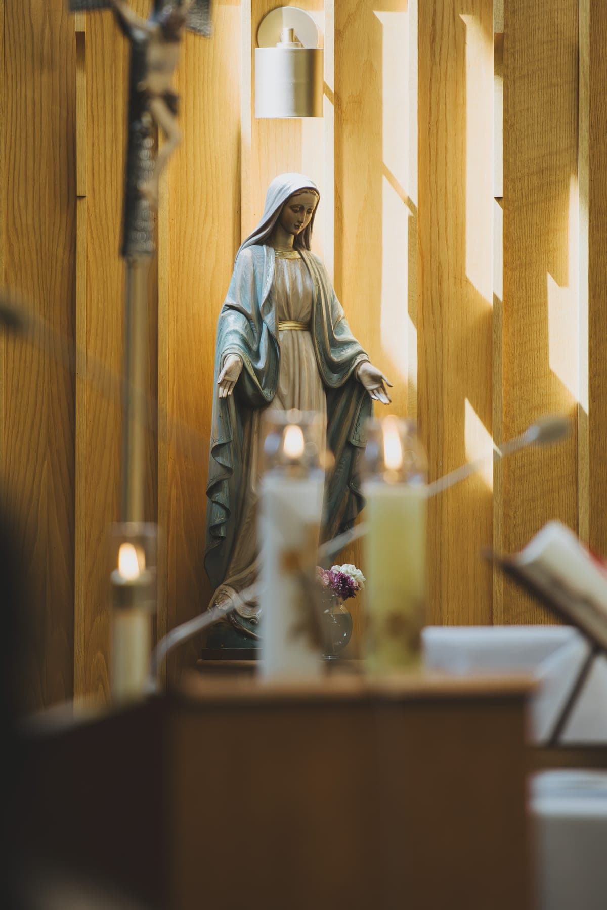 The Marian shrine with votive candles burning and fresh flowers at Our Lady’s feet
