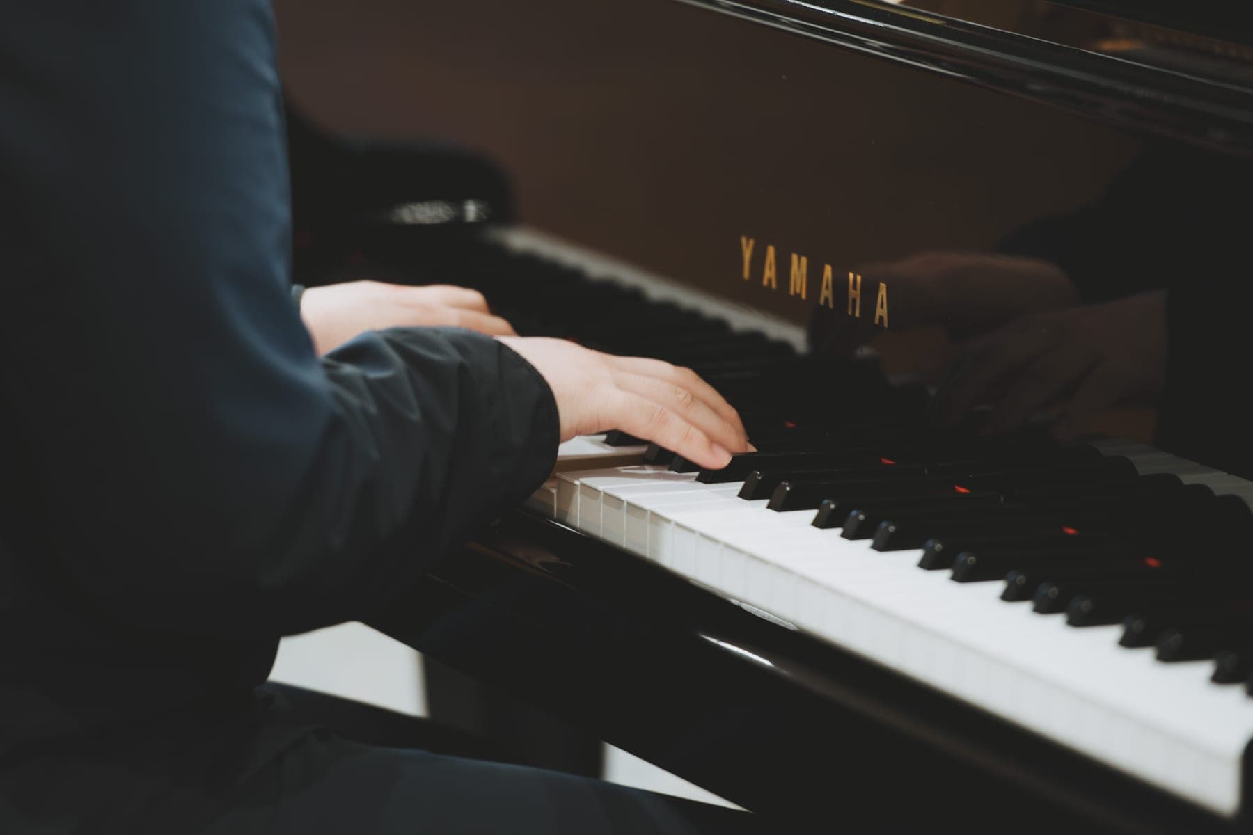 Close view of a musician’s hands playing the grand piano during Mass